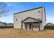 Backyard view of a light brick home featuring a covered porch and ample lawn space at 825 Bufflehead Ct, Stockbridge, GA 30281