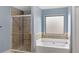 Bathroom featuring tile shower and soaking tub with a window at 825 Bufflehead Ct, Stockbridge, GA 30281