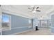 Bright bedroom featuring a ceiling fan, fireplace, and a wall of windows to let in light at 825 Bufflehead Ct, Stockbridge, GA 30281