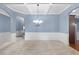 Formal dining area features wainscoting, decorative lighting, and convenient access to the kitchen at 825 Bufflehead Ct, Stockbridge, GA 30281