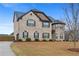 Exterior shot of a stately two-story brick home with well-manicured landscaping and an attached garage at 825 Bufflehead Ct, Stockbridge, GA 30281