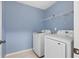 Laundry room with white washer and dryer, light blue walls, and wire shelving at 825 Bufflehead Ct, Stockbridge, GA 30281