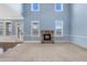 Bright living room with a stone fireplace, tall ceilings, and large windows, providing abundant light at 825 Bufflehead Ct, Stockbridge, GA 30281