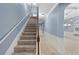 Carpeted staircase with wooden handrail, complemented by decorative wall trim and soft blue paint at 825 Bufflehead Ct, Stockbridge, GA 30281