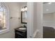 Elegant powder room with dark vanity, decorative mirror and stylish window at 880 Streamside Dr, Mcdonough, GA 30252