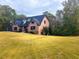 Charming brick home featuring a well-manicured lawn and mature trees in a peaceful, residential setting at 880 Streamside Dr, Mcdonough, GA 30252