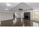Spacious living room featuring dark hardwood floors, a modern ceiling fan, and a cozy fireplace at 880 Streamside Dr, Mcdonough, GA 30252