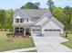 Charming two-story home featuring a two-car garage, well-manicured lawn, and welcoming front porch at 14 Ramble Way, Sharpsburg, GA 30277