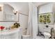 Bright bathroom featuring a tub with shower, vintage fixtures, and a window at 2 W Muscogee Nw Ave, Atlanta, GA 30305