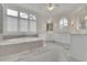 Elegant bathroom features a soaking tub, a round window, and double sinks at 4084 Peachtree Dunwoody Ne Rd, Atlanta, GA 30342
