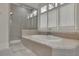 Cozy bathroom displays a glass enclosed shower and a soaking tub under large windows at 4084 Peachtree Dunwoody Ne Rd, Atlanta, GA 30342