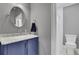 Bathroom featuring a marble vanity with blue cabinets and a separate toilet stall at 4084 Peachtree Dunwoody Ne Rd, Atlanta, GA 30342