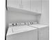Well-lit laundry room features a white Speed Queen washer and dryer, plus upper cabinet storage at 4084 Peachtree Dunwoody Ne Rd, Atlanta, GA 30342