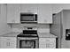 Modern kitchen featuring stainless steel appliances, white cabinetry, and granite countertops at 500 Allen'S Landing Ct, Lawrenceville, GA 30045