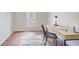 Neutral bedroom featuring a wood-look floor, a window, and a desk area with a modern desk lamp at 6641 Poplar Grove Way, Stone Mountain, GA 30087