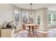 Bright dining area with wood floors and a pendant light fixture is surrounded by large windows at 6641 Poplar Grove Way, Stone Mountain, GA 30087