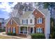 Two-story brick home featuring classic shutters, white trim, and a well-maintained lawn and inviting front porch at 6641 Poplar Grove Way, Stone Mountain, GA 30087