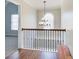 Hallway with wooden railing, hardwood floors, decorative lighting and an arched window at 6641 Poplar Grove Way, Stone Mountain, GA 30087