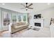 Bright and spacious living room featuring a fireplace, large windows, and a ceiling fan at 6641 Poplar Grove Way, Stone Mountain, GA 30087