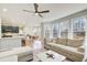 Open-concept living room features modern ceiling fan, large windows, and adjoins a kitchen and dining area at 6641 Poplar Grove Way, Stone Mountain, GA 30087