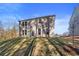 View of the backyard, two-story brick home, with a grassy hill, windows, and a door at 129 Belvedere Rd, Mcdonough, GA 30253