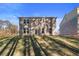 Backyard view of brick two-story home with many windows and a door, landscaped with a grass hill at 129 Belvedere Rd, Mcdonough, GA 30253