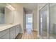 Bathroom boasts a double vanity, glass shower stall, vinyl floors, and a view of another room at 129 Belvedere Rd, Mcdonough, GA 30253