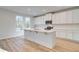 Modern kitchen with white cabinets, a large island, and stainless steel appliances at 129 Belvedere Rd, Mcdonough, GA 30253