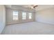 Spacious main bedroom with tray ceilings, three large windows, and neutral carpet at 129 Belvedere Rd, Mcdonough, GA 30253