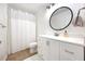 Bathroom showcasing a modern vanity with a round mirror and a shower with white tile and shower curtain at 135 Cowan Trl, Stockbridge, GA 30281