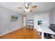 Bedroom with hardwood floors, ceiling fan, and a wall-mounted television over a modern desk at 135 Cowan Trl, Stockbridge, GA 30281