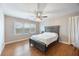 Bright bedroom with wood-look floors, a ceiling fan, and a cozy bed near a bright window at 135 Cowan Trl, Stockbridge, GA 30281