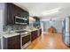 Modern kitchen featuring dark wood cabinets, stainless steel appliances, and a seamless transition to the dining area at 135 Cowan Trl, Stockbridge, GA 30281