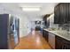 Stylish kitchen with dark wood cabinets, stainless steel appliances, and an open layout leading to a breakfast area at 135 Cowan Trl, Stockbridge, GA 30281
