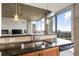 Kitchen features stainless steel sink, dark granite counters, and incredible skyline views at 855 Peachtree St # 2901, Atlanta, GA 30308
