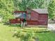 Charming red home featuring unique architecture, a well-maintained lawn and mature trees at 2375 Justine Ter, Lithia Springs, GA 30122
