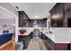 Galley kitchen with dark wood cabinetry, white countertops, and stainless steel appliances at 2375 Justine Ter, Lithia Springs, GA 30122