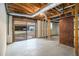 Unfinished basement with sliding glass doors and exposed beams on concrete floors at 405 Putting Green Ln, Roswell, GA 30076