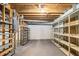 Unfinished basement featuring exposed wood beams and metal shelving on concrete floors at 405 Putting Green Ln, Roswell, GA 30076