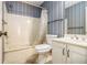 Bathroom with shower-tub combination, white vanity and sink, and vertical striped wall paper at 405 Putting Green Ln, Roswell, GA 30076