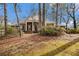 Charming one-story brick home with a columned front porch surrounded by mature trees on a lush lawn at 405 Putting Green Ln, Roswell, GA 30076