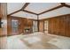 Living room showcasing a fireplace, wood-paneled walls, and a walk-out to the back of the home at 405 Putting Green Ln, Roswell, GA 30076