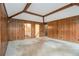 Room featuring wood paneled walls, beamed ceilings, and doorways leading to other rooms at 405 Putting Green Ln, Roswell, GA 30076