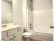 Neutral toned bathroom featuring a shower-tub combo, single sink vanity, and tile flooring at 1649 Auburn Ridge Way, Dacula, GA 30019