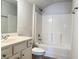 Neutral toned bathroom featuring a shower-tub combo, single sink vanity, and tile flooring at 1649 Auburn Ridge Way, Dacula, GA 30019
