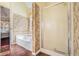 Bathroom featuring a soaking tub, glass shower, and decorative wallpaper at 606 Wedgewood Dr, Woodstock, GA 30189