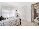 Bright bedroom with white walls, carpet and doors next to a bathroom entrance at 606 Wedgewood Dr, Woodstock, GA 30189