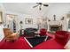 Inviting living room with a stone fireplace, bright windows, and plush red carpeting at 606 Wedgewood Dr, Woodstock, GA 30189