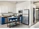 Modern kitchen with white cabinets, blue lower cabinets, stainless steel appliances, kitchen island, and laundry closet at 791 Wylie Se St # 105, Atlanta, GA 30316