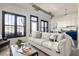Living room featuring neutral furniture with a view of the kitchen, white brick wall and a large window with dark trim at 791 Wylie Se St # 105, Atlanta, GA 30316